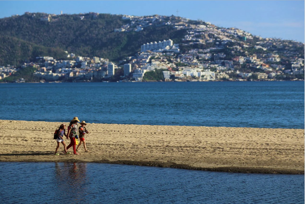 2023年11月24日，奧蒂斯颶風襲擊墨西哥阿卡普爾科一個月后，人們在海灘上行走。