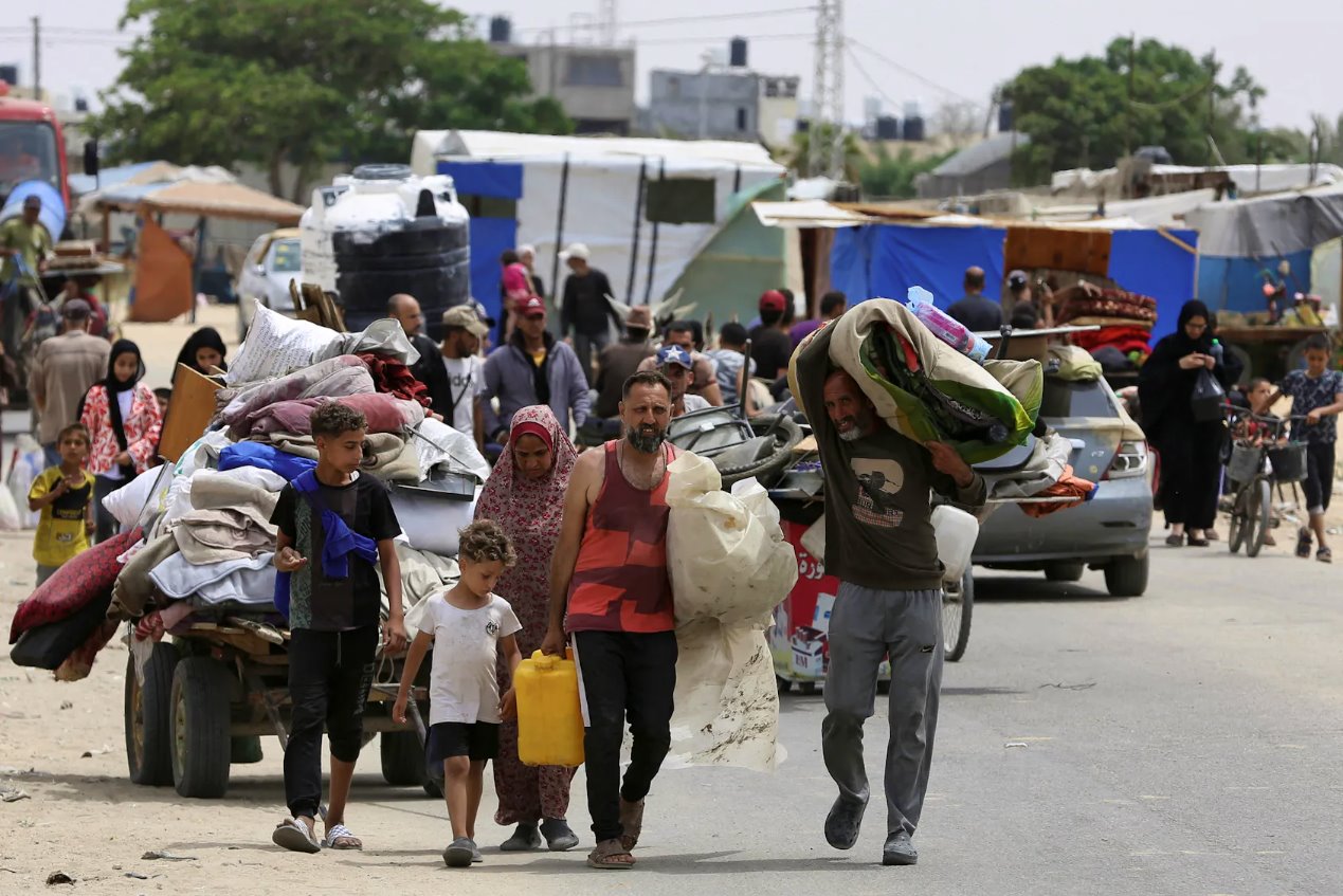 2024年5月28日,加沙地帶南部拉法,巴勒斯坦人因以色列軍事行動而帶著財物步行逃離拉法。