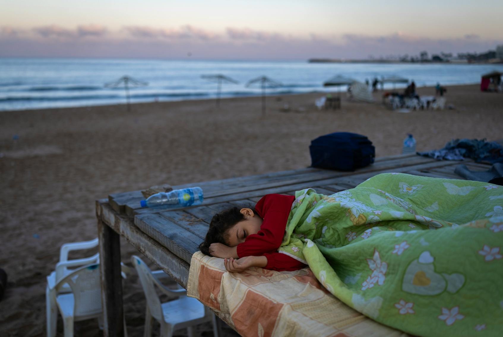 2024年9月29日,黎巴嫩貝魯特,一名男孩和家人逃離空襲,在貝魯特的RamletAlBaida海灘避難。
